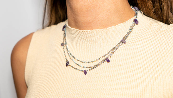 Woman wearing metal chain necklace with amethyst chips