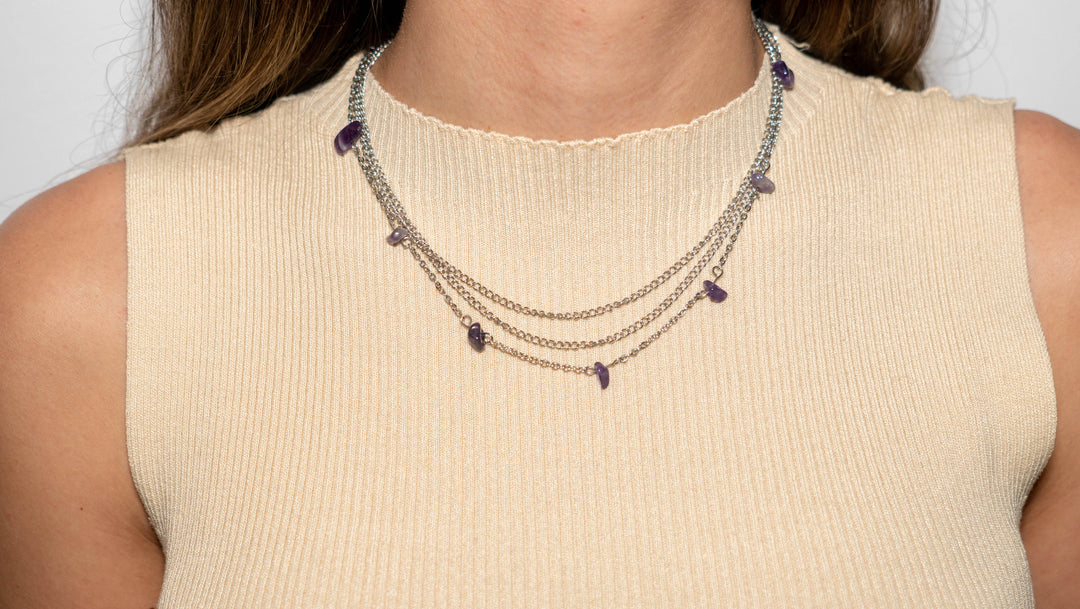 Woman wearing metal chain necklace with amethyst chips